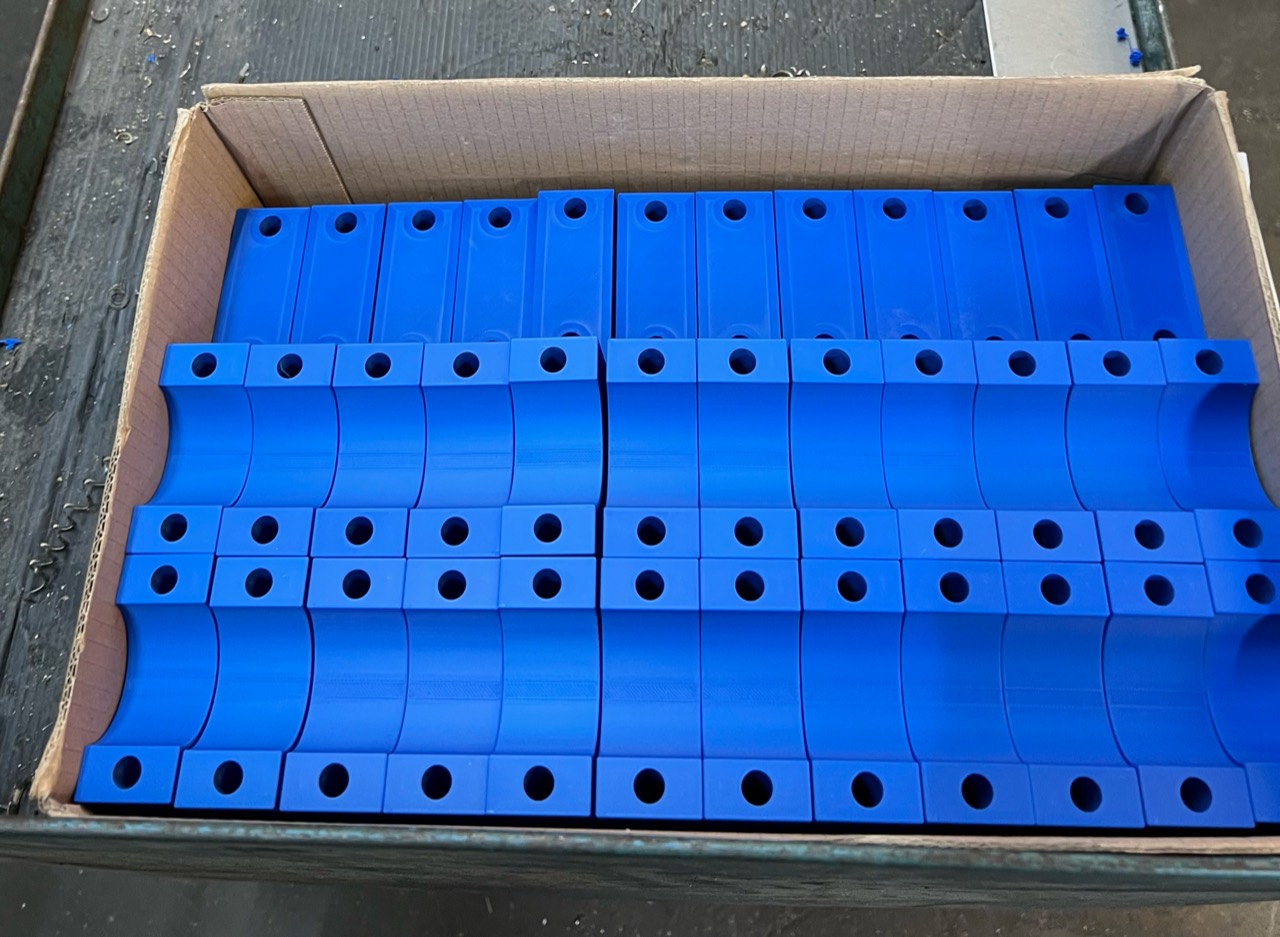 Mehrere blaue, gedruckte Kundenbauteile in einer Schachtel
